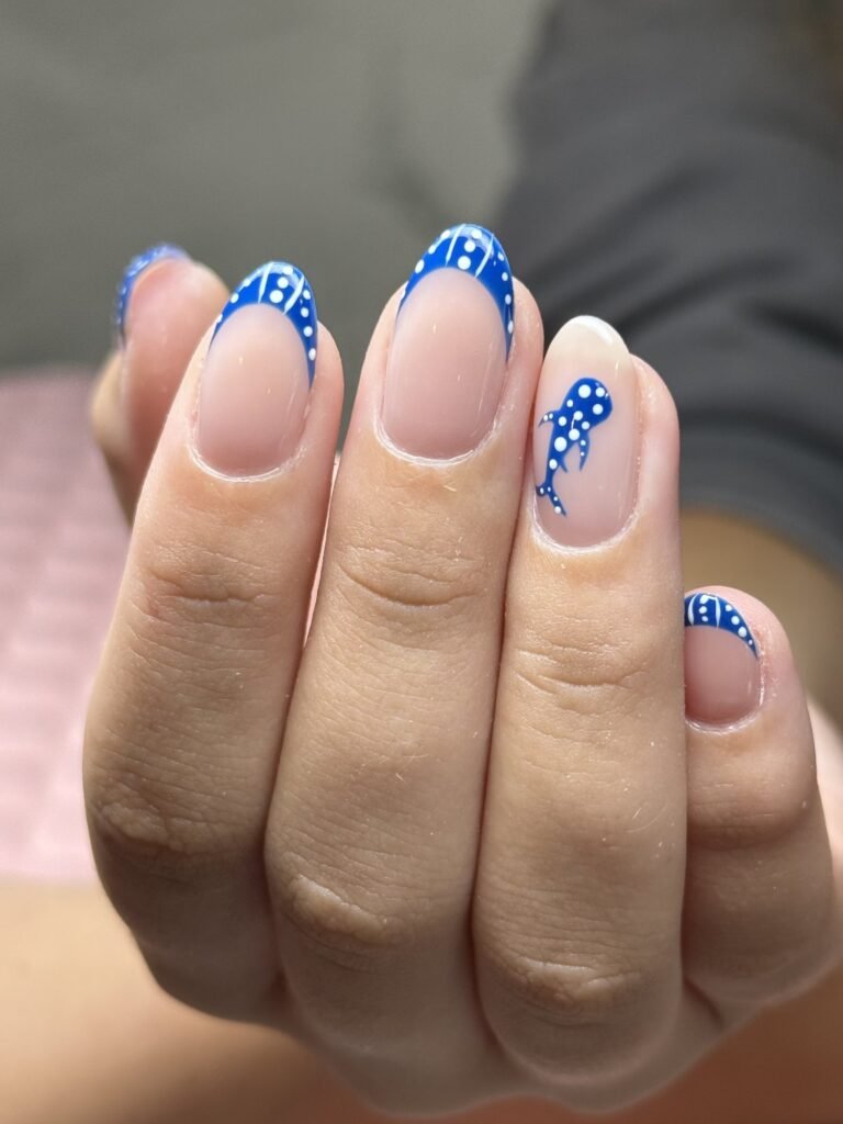 Blue French tips with polka dot accents at Nailbox Co.