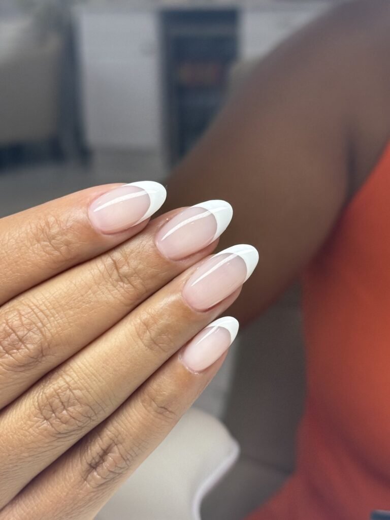 Classic white French tips on almond nails at Nailbox Co.