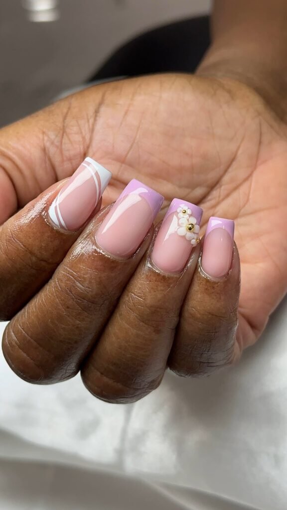 Lavender and white French tips with a painted flower accent at Nailbox Co.