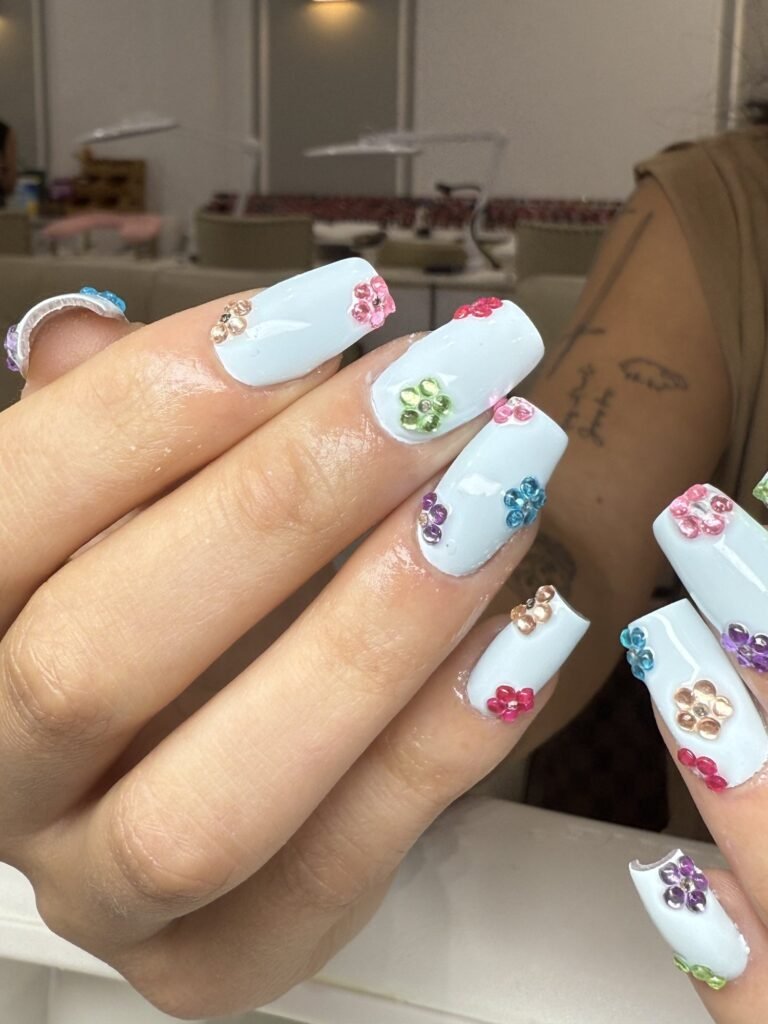 White coffin nails with 3D rhinestone flowers at Nailbox Co.