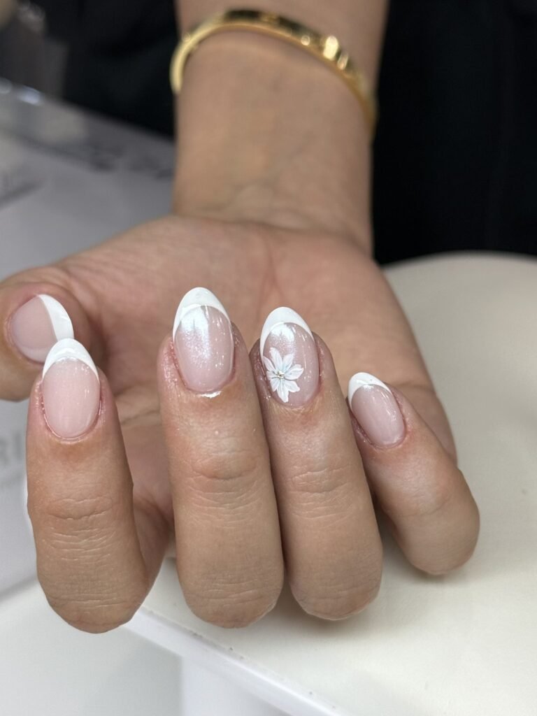 White French tips with a floral accent nail at Nailbox Co.